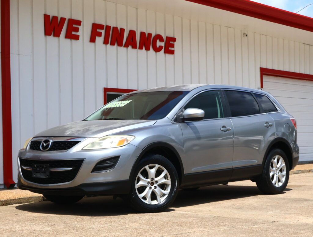 Silver SUV parked in front of a white building with red trim and the 'WE FINANCE' sign above.