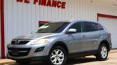 Silver SUV parked in front of a white building with red trim and the 'WE FINANCE' sign above.