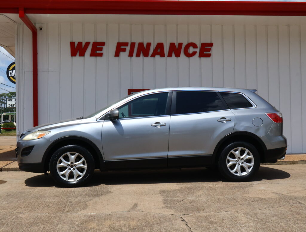 Silver SUV parked in front of a white wall with a large red 'WE FINANCE' sign.