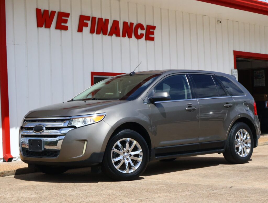 Gray SUV parked in front of a white wall with bold red 'WE FINANCE' lettering visible above it.