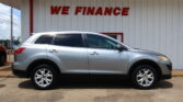 Silver SUV parked in front of a white building with bold red 'WE FINANCE' sign above it.