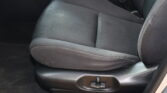 Black fabric car seat with visible seat belt buckle and center console area nearby.