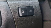 Car interior: two black heated-seat buttons on a textured dashboard with seat icon graphics