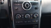 Center dashboard with car stereo controls: CD/FM/AM, volume knob, and climate dials surrounding a circular control.