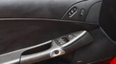 Car interior door panel showing window controls, lock switch, and a Bose speaker grille nearby.