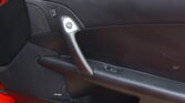 Interior of a car door: black panel with a visible Bose speaker badge, door handle, and window switch nearby.