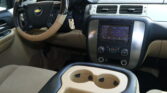 Beige center console with two cup holders visible between the front seats in a car interior.