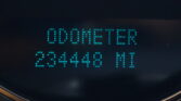Close-up of a car dashboard LED readout in blue, showing digits '0000' on a dark background.